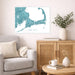Living room with a map of Cape Cod on the wall, a couch, and a wooden side table with decor items.