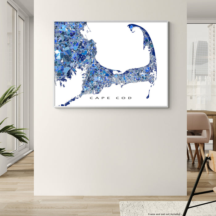 Map of Cape Cod in blue and white on a wall in a room with a chair and plant.