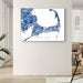 Map of Cape Cod in blue and white on a wall in a room with a chair and plant.
