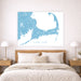 Map of Cape Cod on a wall above a bed with nightstands and lamps.