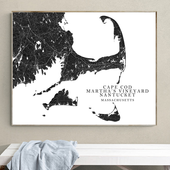 Framed map of Cape Cod, Martha's Vineyard, and Nantucket on a wall above a white surface.