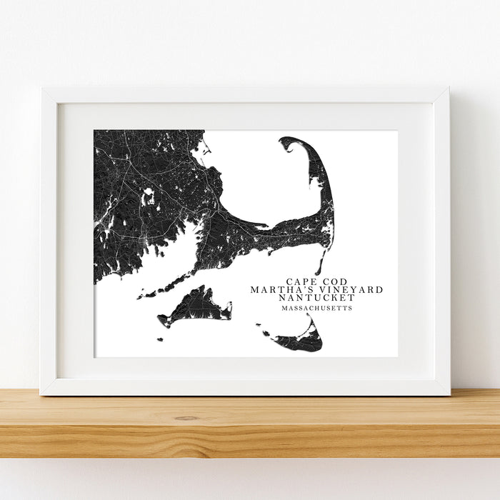 Framed black and white map of Cape Cod, Martha's Vineyard, and Nantucket on a wooden shelf.