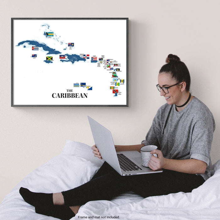 Caribbean island map framed hanging above a woman reading laptop.