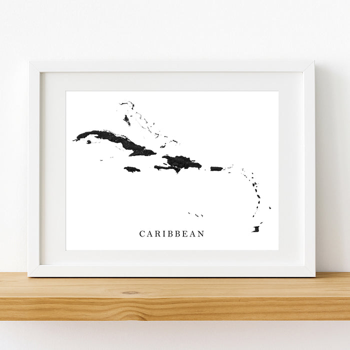 Framed black and white map of the Caribbean on a wooden shelf.