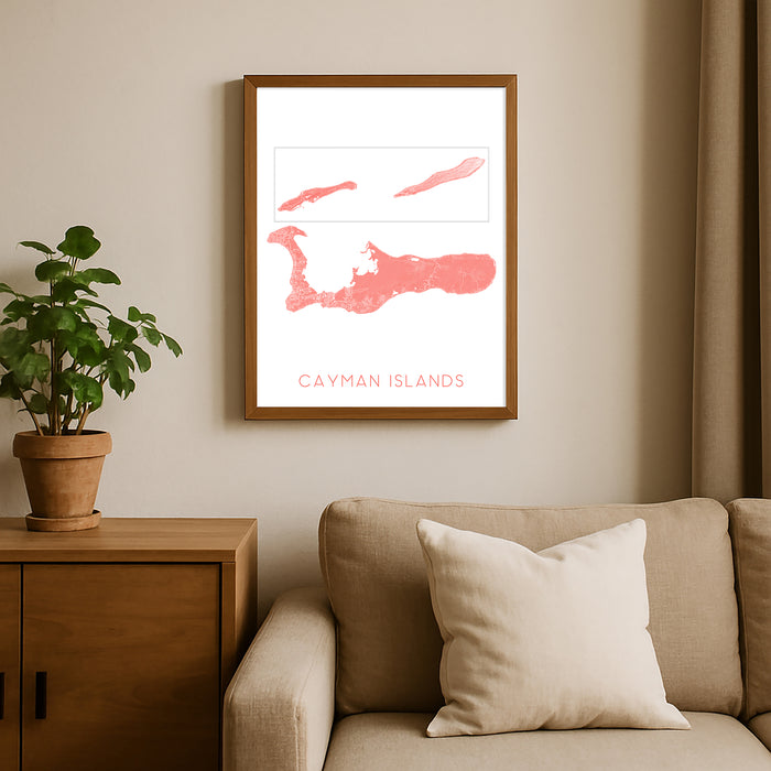 Framed map of Cayman Islands on a wall above a sofa with a plant beside it.