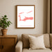 Framed map of Cayman Islands on a wall above a sofa with a plant beside it.