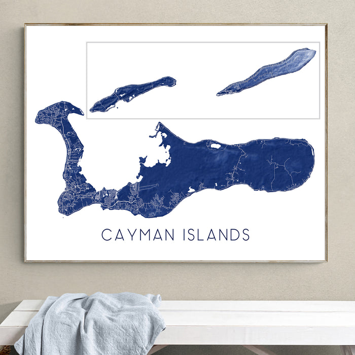 Framed map of the Cayman Islands on a wall above a white bench.