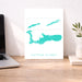 Map of Cayman Islands on a white background next to a laptop on a wooden desk.