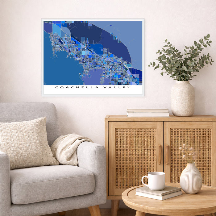 Living room with a map of Coachella Valley on the wall, a couch, and a side table with decor items.