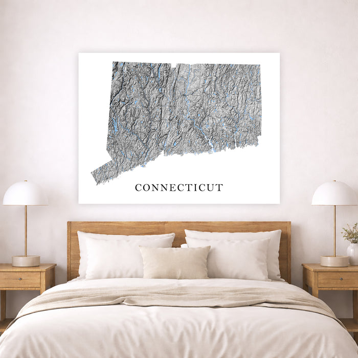 Map of Connecticut on a wall above a bed in a bedroom setting