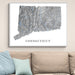 Framed map of Connecticut on a wall above a beige sofa with blue pillows.