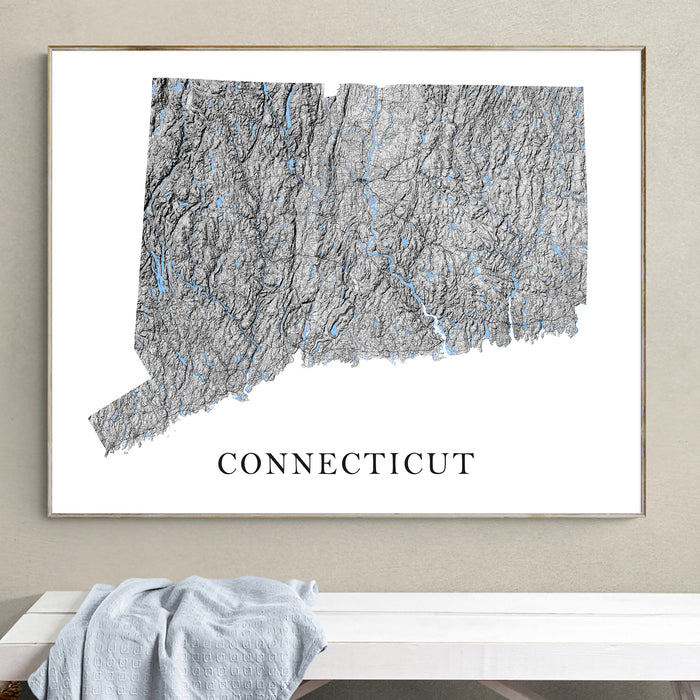 Framed topographic map of Connecticut on a wall above a white bench.