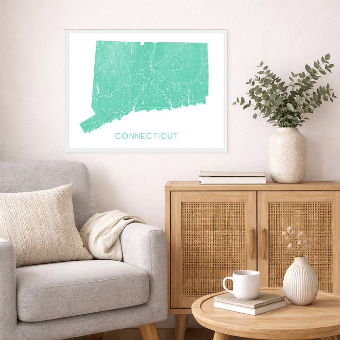 Living room with a map of Connecticut on the wall, a gray sofa, wooden cabinet, and decorative items.