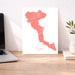 Map of Corfu on a white background next to a laptop on a wooden desk.