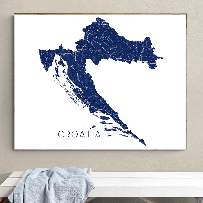 Framed map of Croatia on a wall above a white surface.