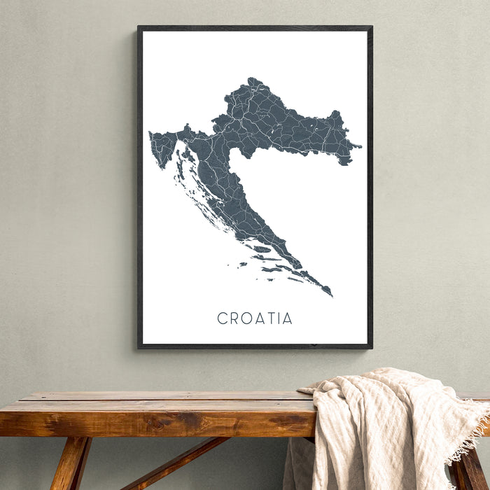 Framed map of Croatia on a wall above a wooden bench.