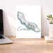 Map of Curacao on a desk with a laptop and plant.