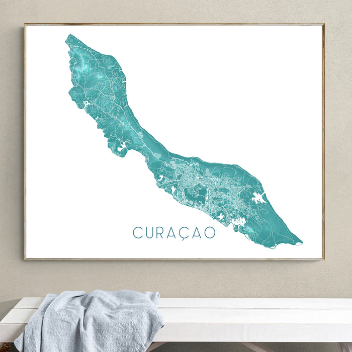 Framed map of Curacao on a wall above a white bench.