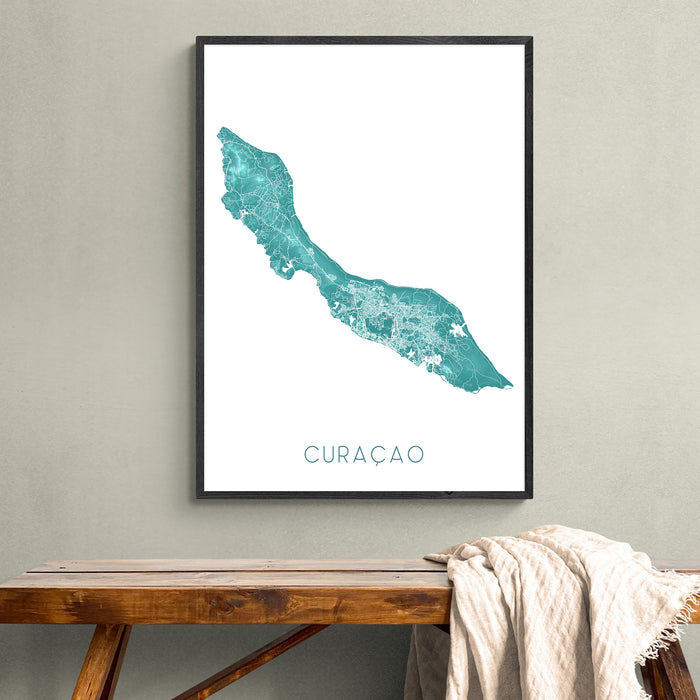 Framed map of Curacao on a wall above a wooden bench.