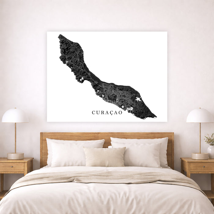 Map of Curaçao on a wall above a bed in a bedroom.