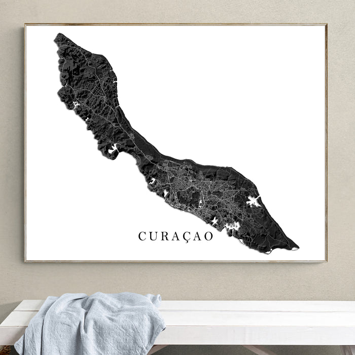 Framed map of Curaçao on a wall above a white surface.