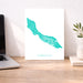 Map of Curacao on a white background next to a laptop on a wooden desk.