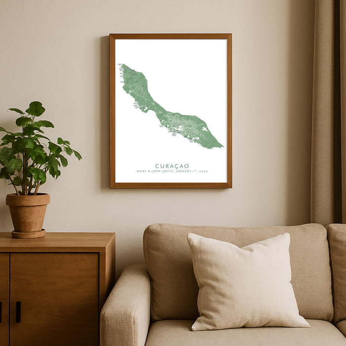 Framed map of Curacao on a wall above a sofa with a plant beside it.