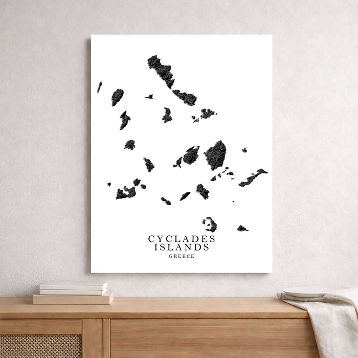 Map of Cyclades Islands on a white wall above a wooden shelf.