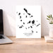 Map of Cyclades Islands on a white background, displayed on a wooden desk with a laptop and plant.