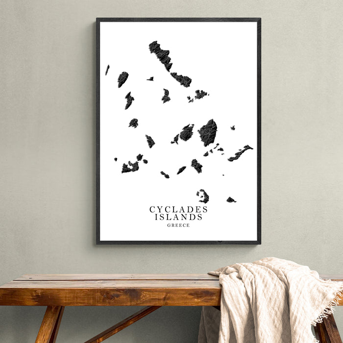 Framed map of Cyclades Islands on a wall above a wooden bench.