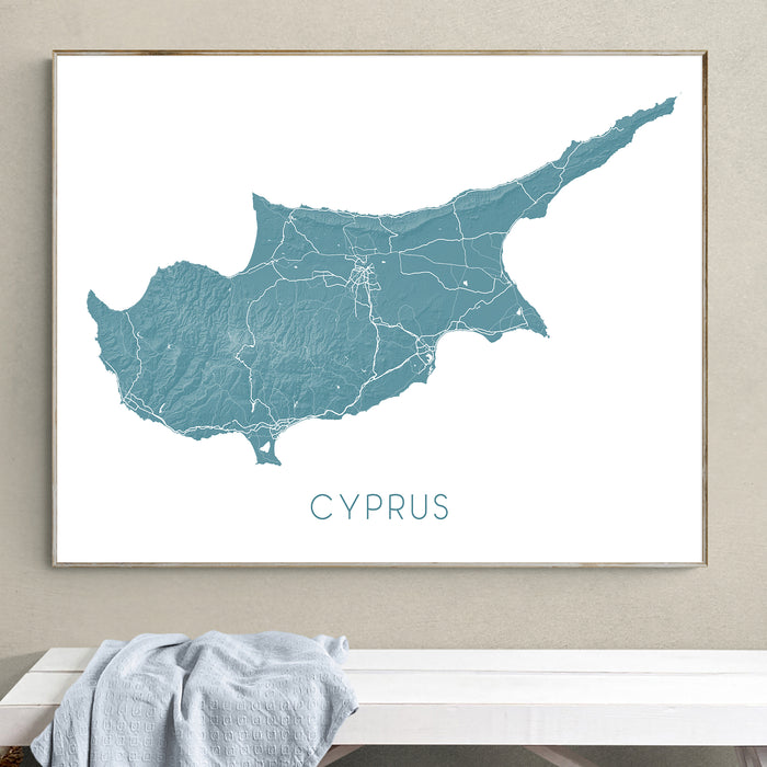 Framed map of Cyprus on a wall above a white bench.