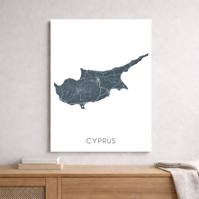 Map of Cyprus on a white wall above a wooden shelf.