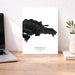 Map of the Dominican Republic on a white background next to a laptop on a wooden desk.