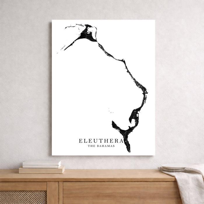 Map of Eleuthera, The Bahamas on a white wall above a wooden shelf.