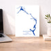 Map of Eleuthera, The Bahamas on a white background with a laptop and plant in the background.