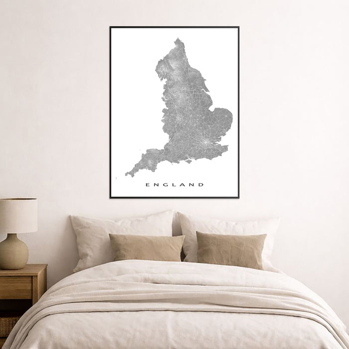 Map of England framed on a wall above a bed in a bedroom.