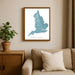 Framed map of England on a wall above a sofa with a plant beside it.