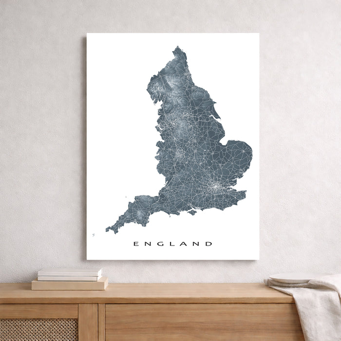 Map of England on a white wall above a wooden cabinet.