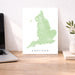 Map of England on a white background next to a laptop on a wooden desk.