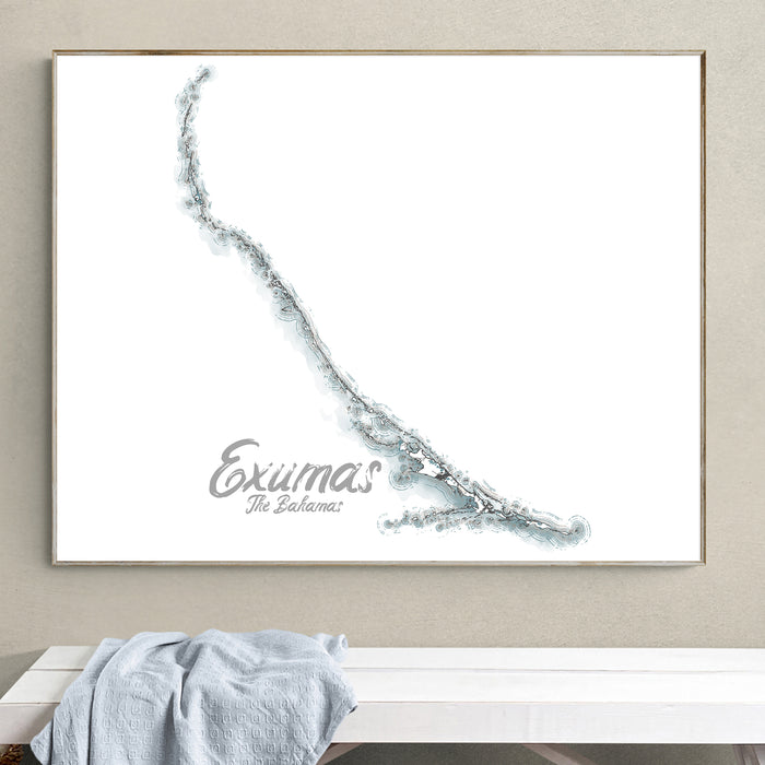 Framed map of Exumas, The Bahamas on a wall above a white bench.