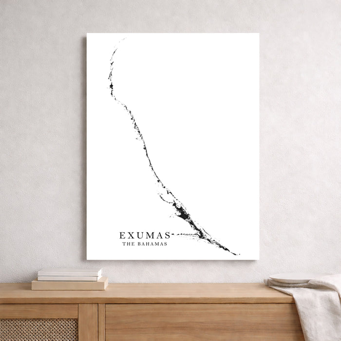 Map of Exumas, The Bahamas on a white wall above a wooden shelf.
