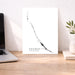 Desk with a laptop, plant, and a map of Exumas on a white background