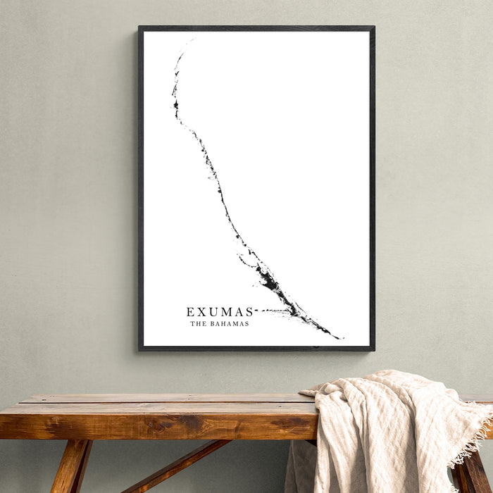 Framed map of Exumas, The Bahamas on a wall above a wooden bench.
