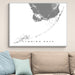 Framed map of the Florida Keys on a wall above a beige sofa with blue pillows.