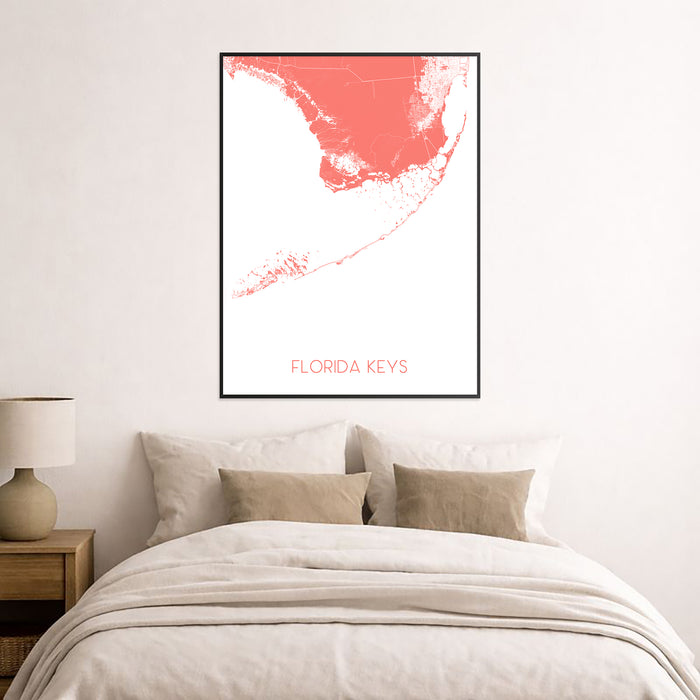 Framed map of Florida Keys on a wall above a bed with neutral bedding.
