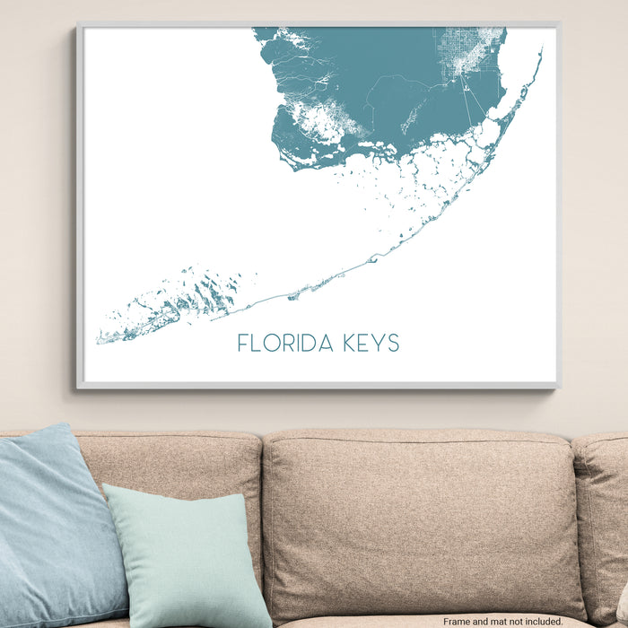 Framed map of the Florida Keys on a wall above a beige couch with light blue pillows.