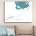 Framed map of the Florida Keys on a wall above a beige couch with light blue pillows.