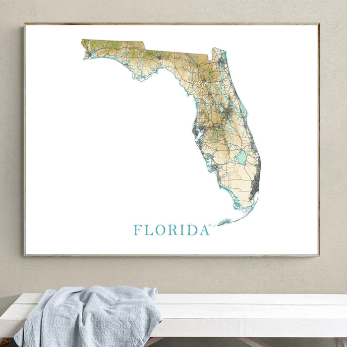 Framed map of Florida on a wall above a white surface with a towel.
