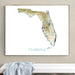 Framed map of Florida on a wall above a white surface with a towel.