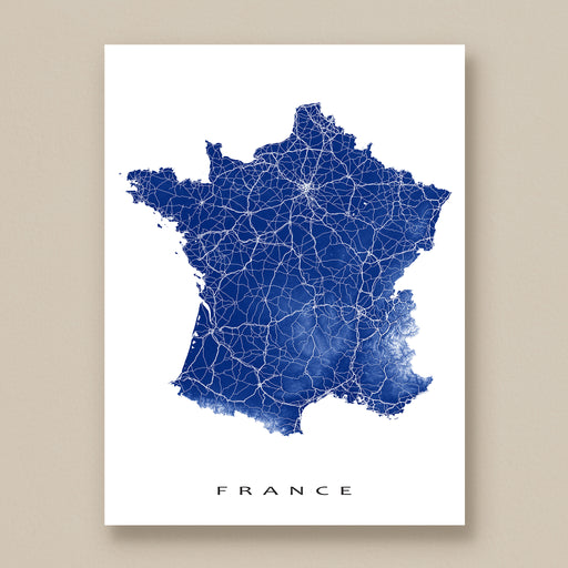 Map of France with blue roads on a white background, displayed on a beige wall.